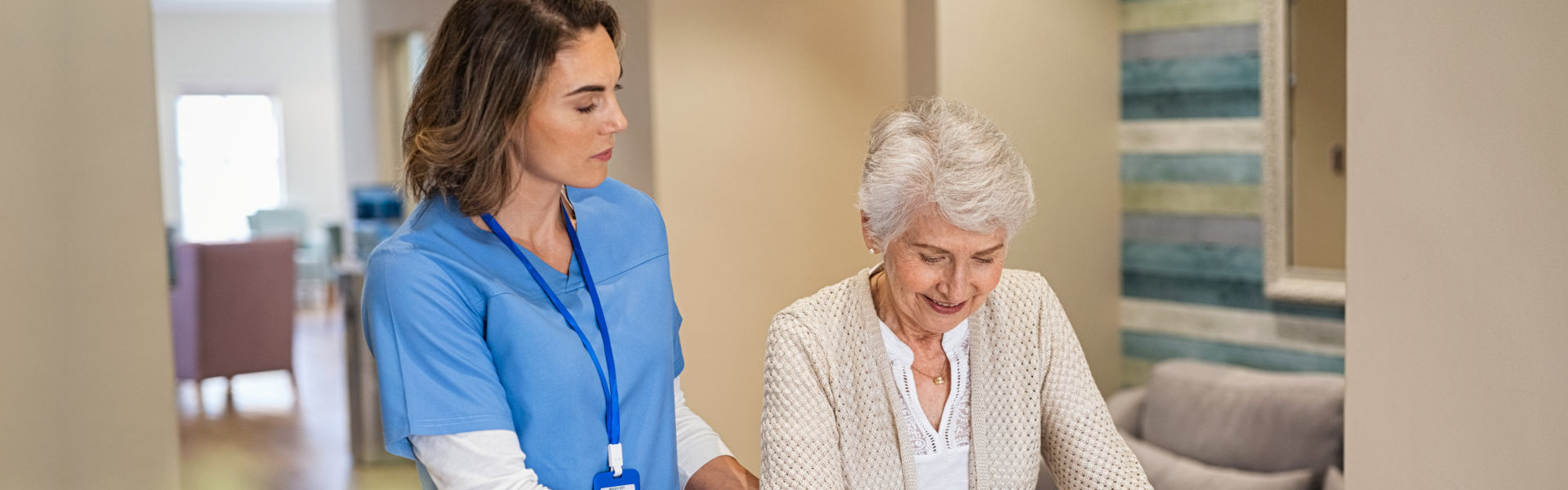 A female caregiver assisting a senior woman