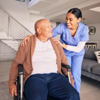 A female caregiver and senior man sitting on a wheelchair