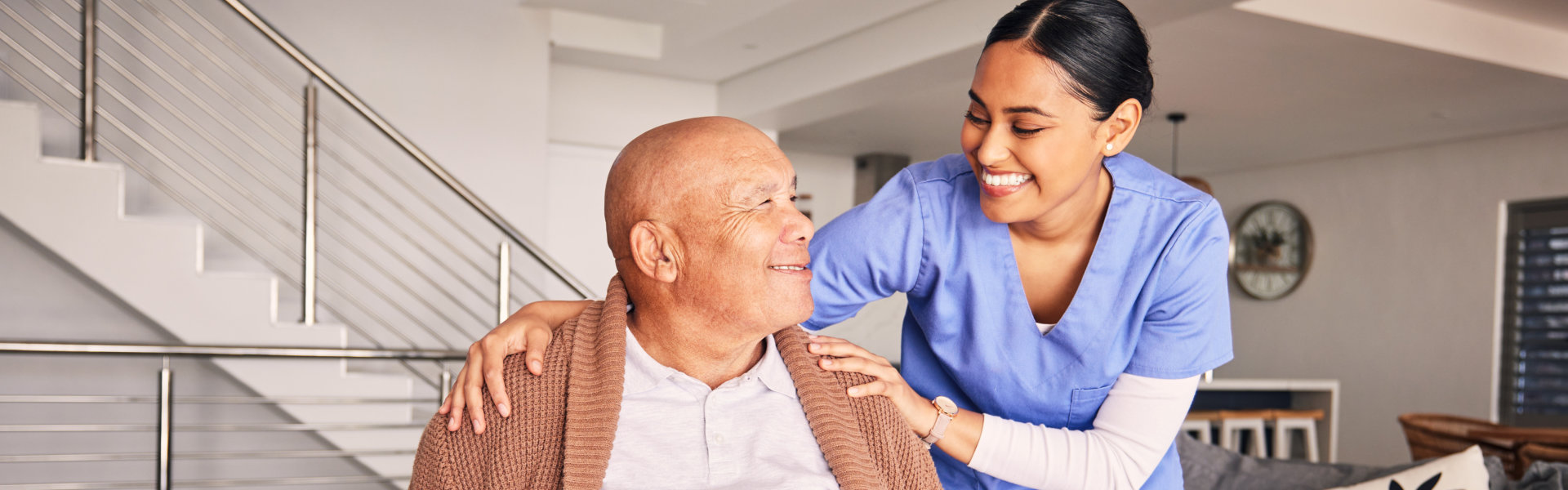 A female caregiver and senior man sitting on a wheelchair